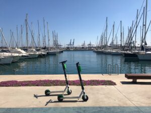 black and green kick scooter beside body of water during daytime