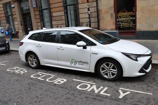 A white electric car from the Co Wheels car-sharing club in Glasgow, parked in a club bay