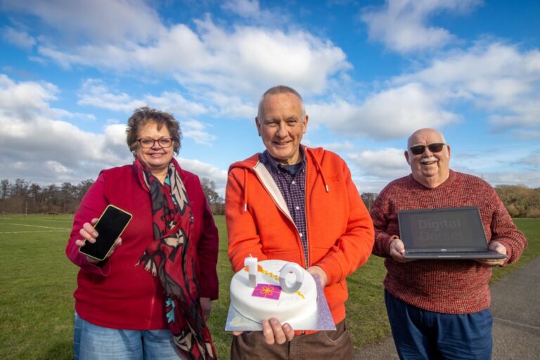 Three of Dorset's volunteer digital champions with a celebratory birthday cake, photo courtesy of Dorset Council