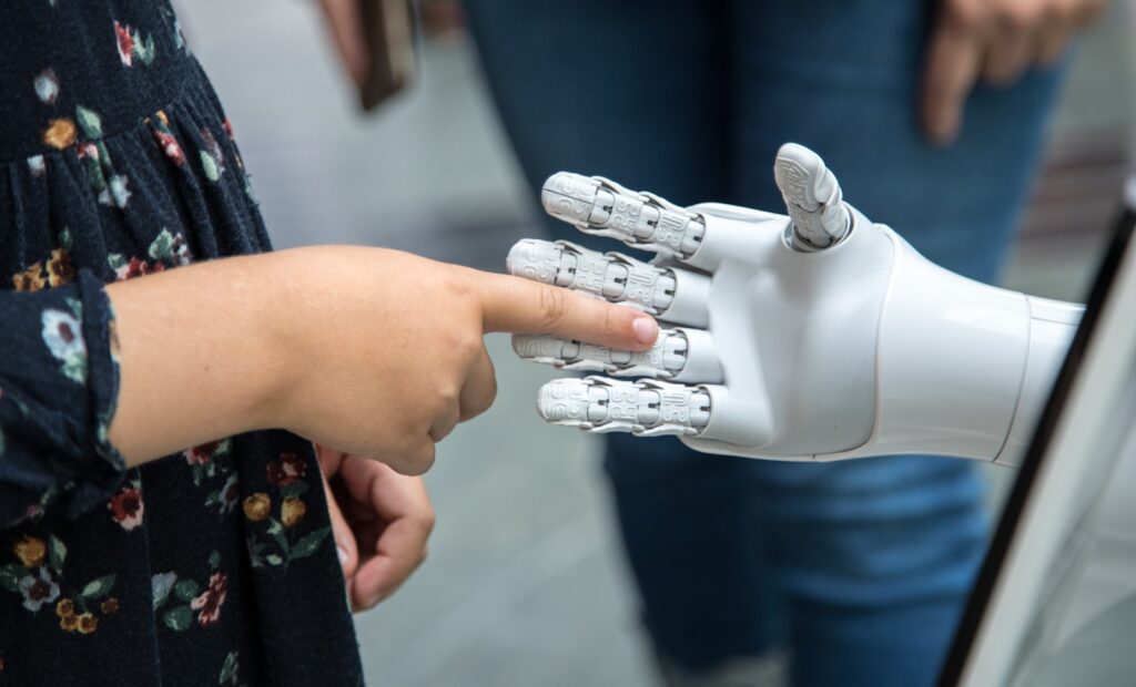 a person holding a robotic hand in front of a mirror