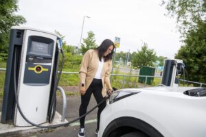 Woman charging an electric vehicle as a chargepoint