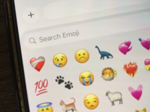 Menu of emoji with words "Search Emoji" above a bandaged heart icon, crying face icon and sad face icon